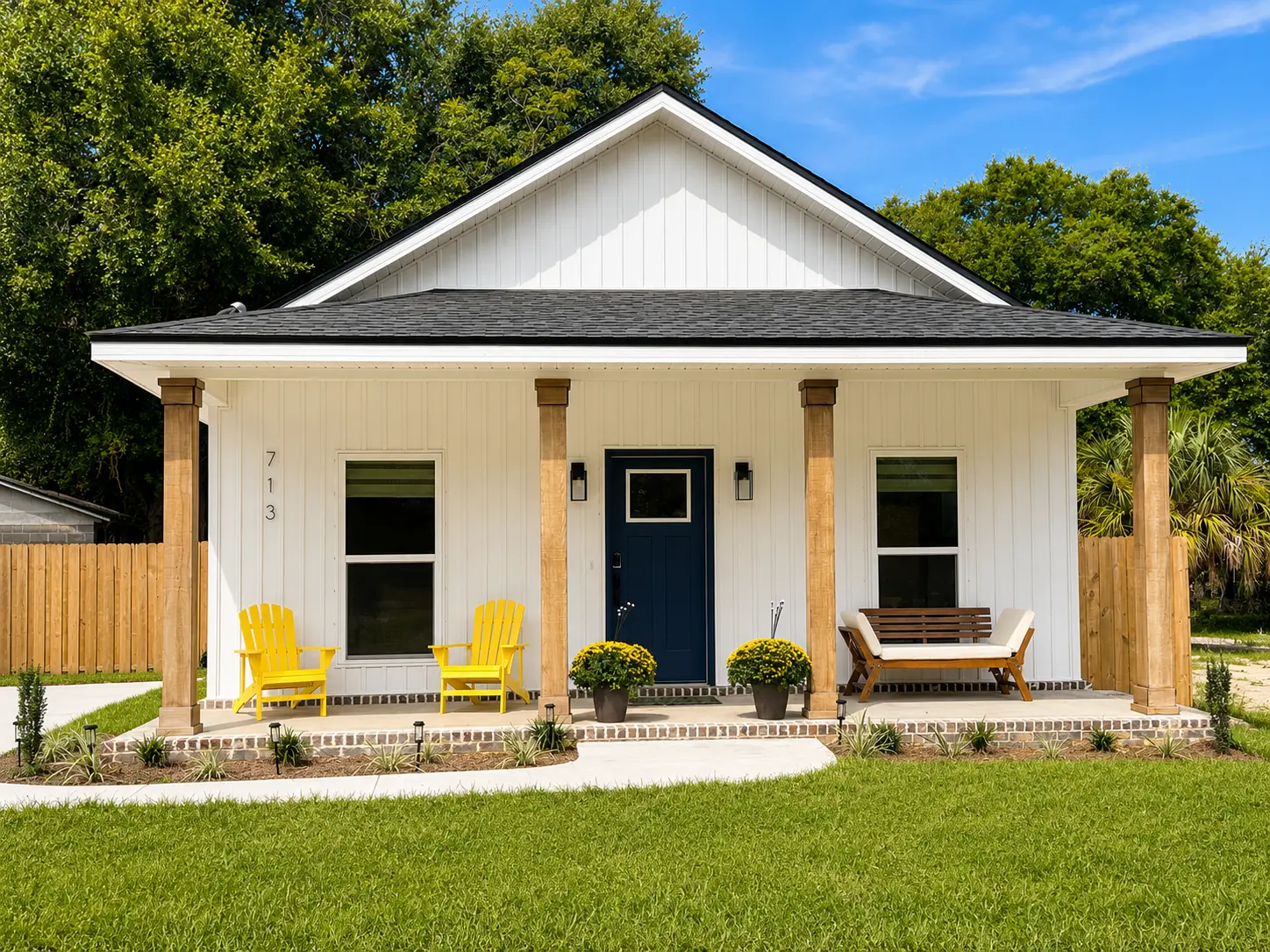 Front exterior of SunKissed on the Coast, a white cottage with covered porch in Pensacola