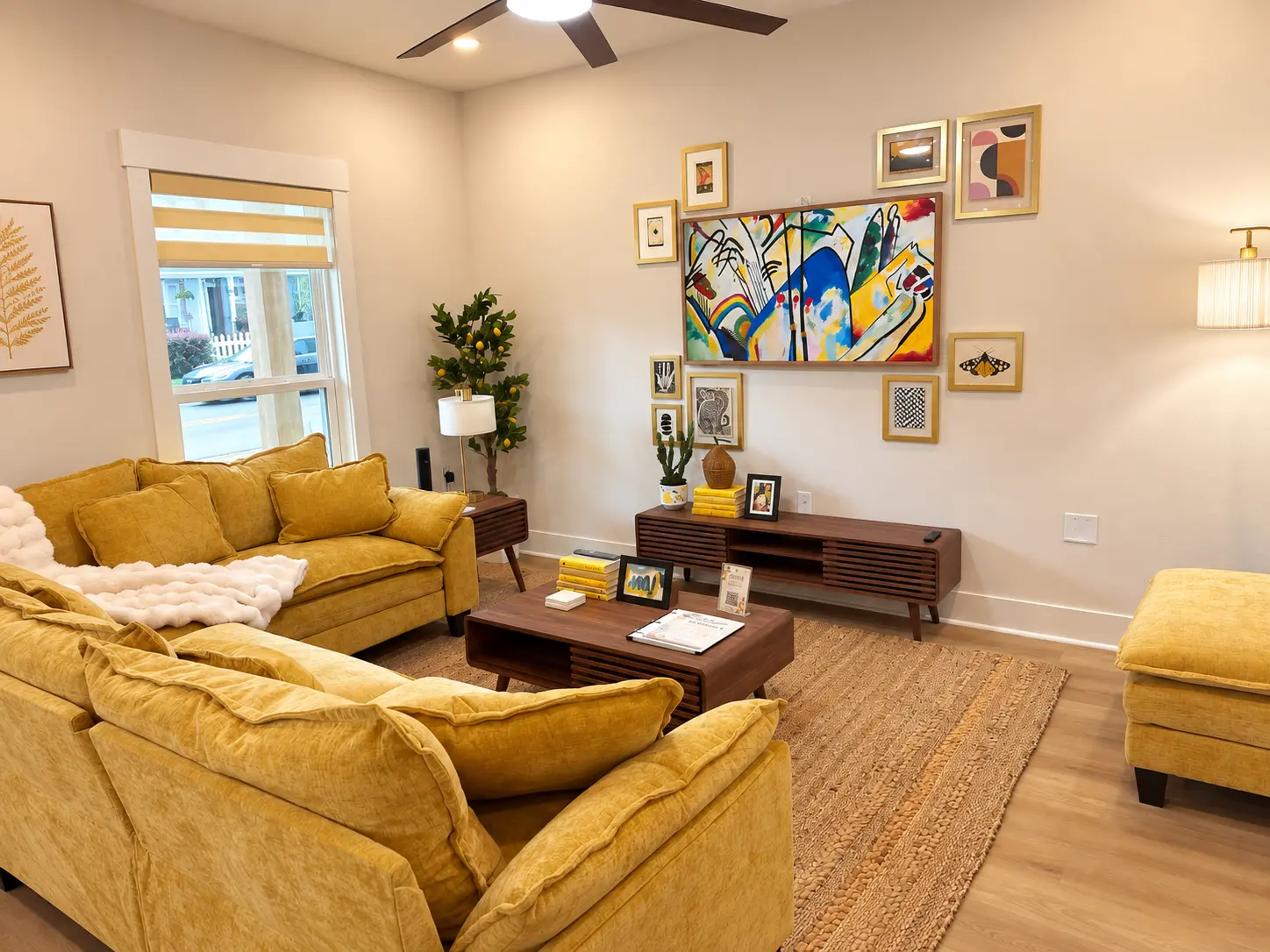 Living room with mustard velvet sectional, walnut media console and a bright gallery wall