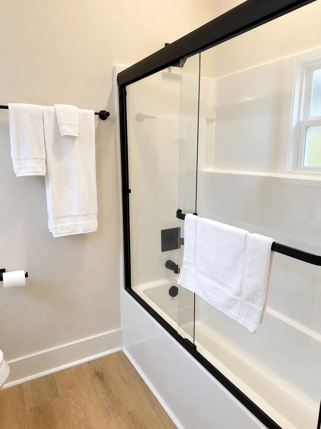 Guest bath tub and shower combination with glass doors and fresh towels