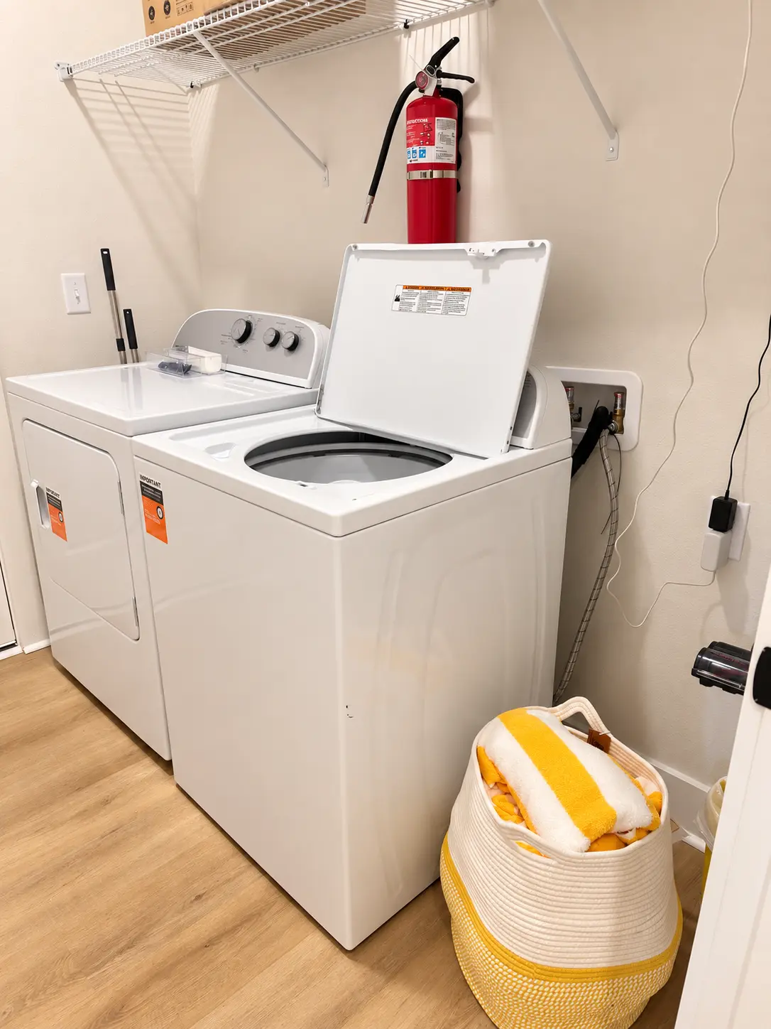In-unit laundry room with full size washer and dryer, beach towels and fire extinguisher