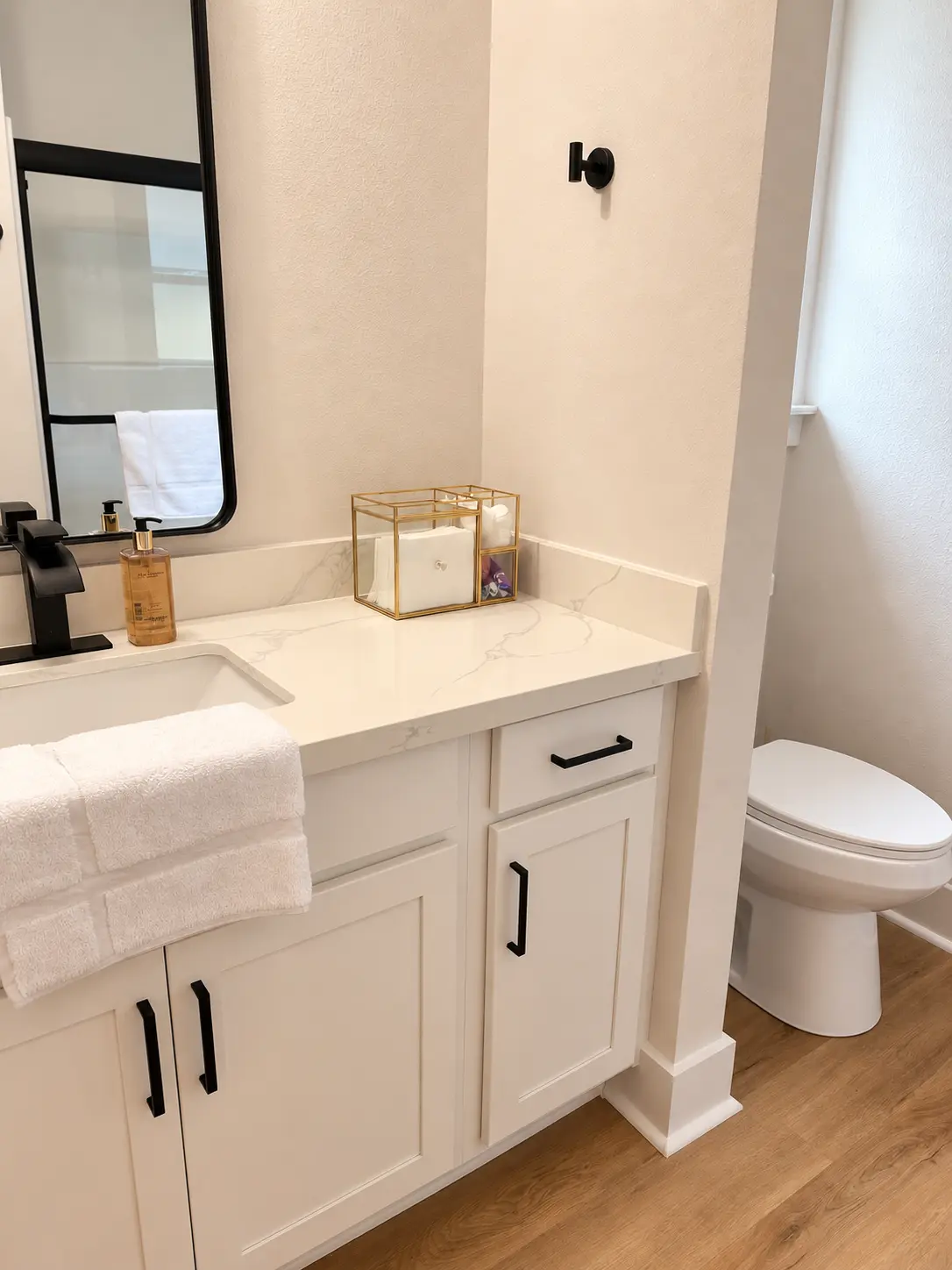 Second bathroom with quartz vanity, hand soap and private toilet area
